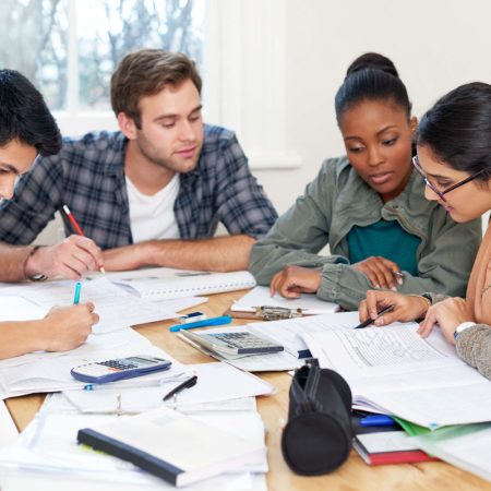 Team, students and reading book in college for education, knowledge or brainstorming together. University, group and people writing notes for information, learning and help for math exam in class.